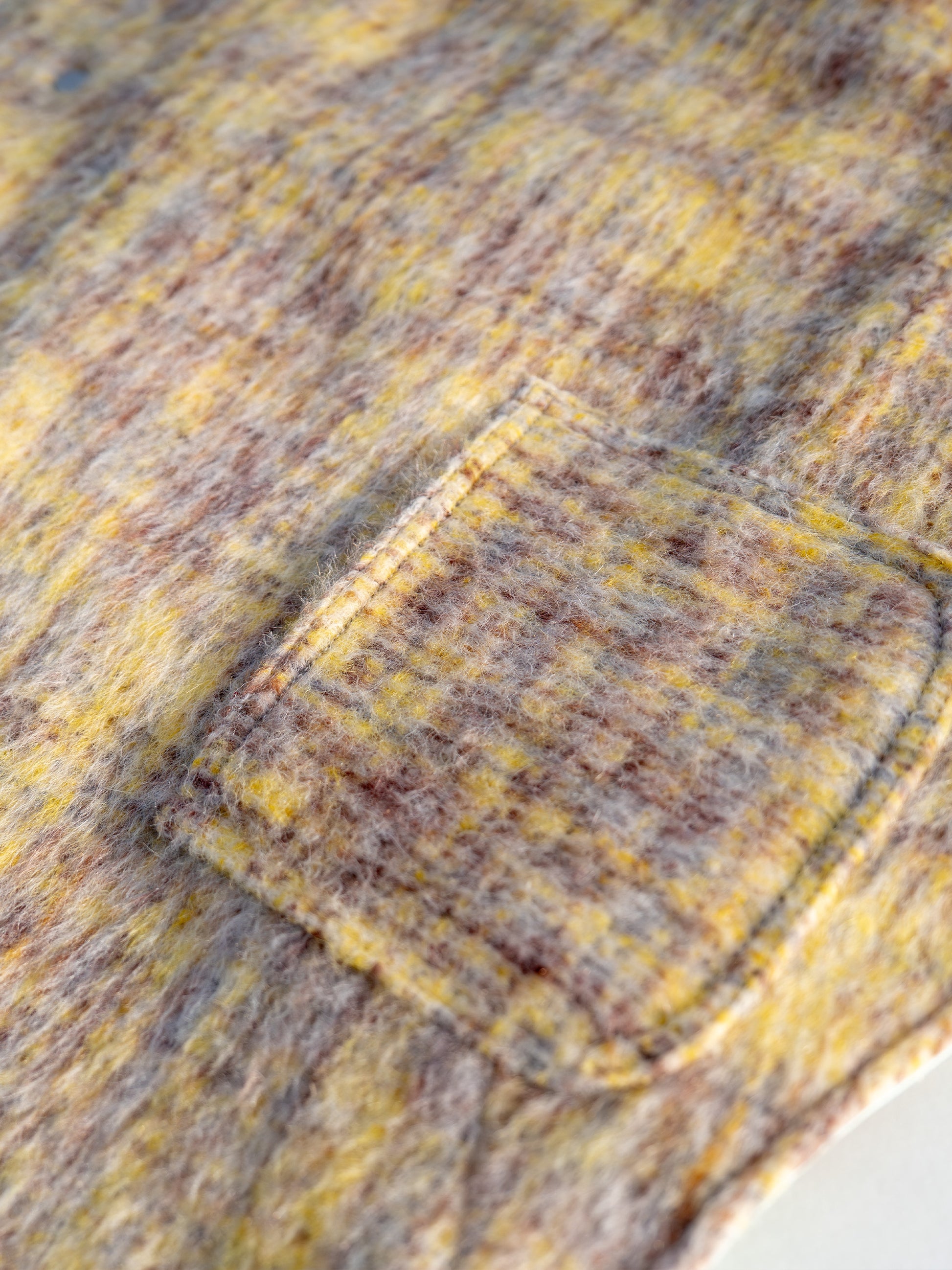 Close-up of functional mini pocket on KIDCORE reversible wool vest, perfect for carrying waste bags or treats